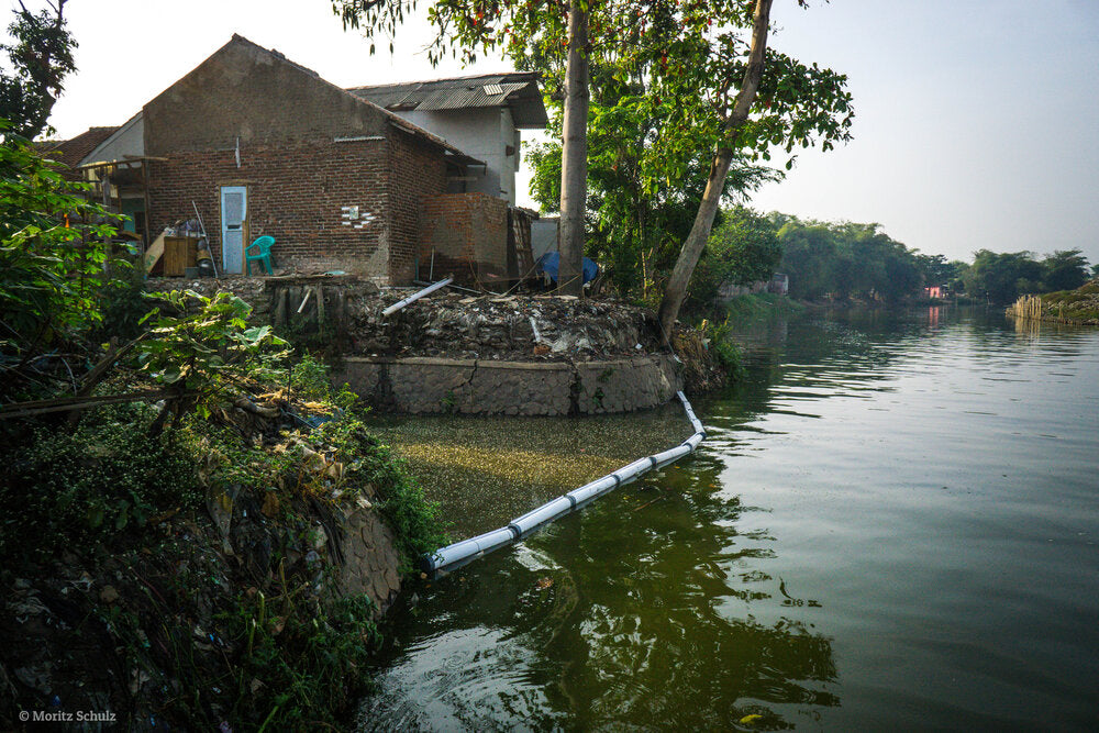 Plastic Fischer barriers blocking plastic and marine debris from entering watershed in Indonesia.